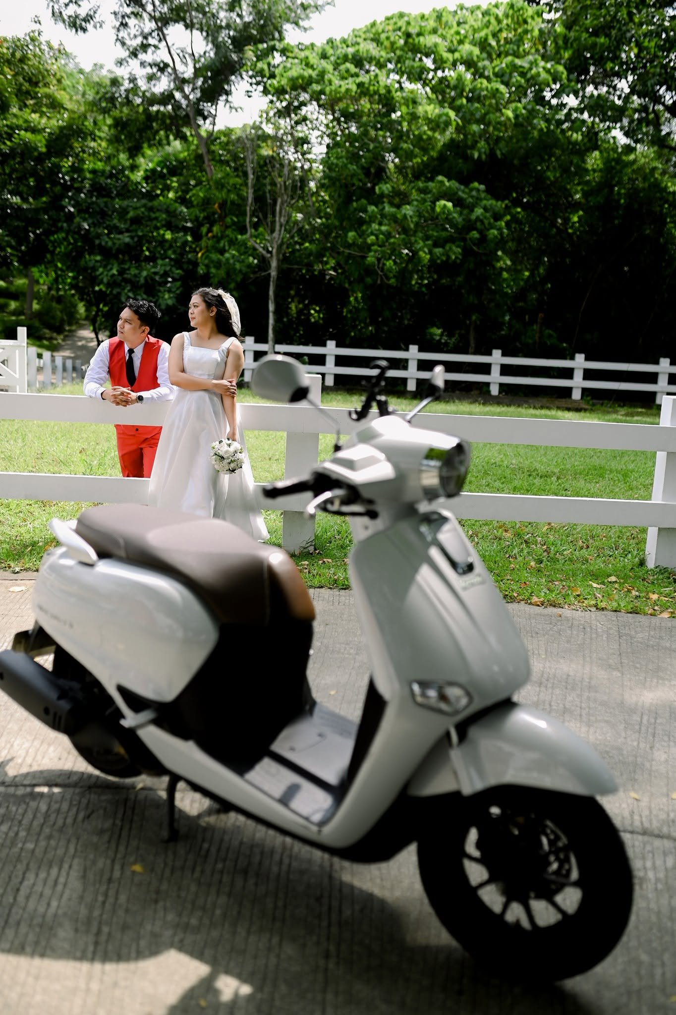 Chie and Cath standing at a white fence, a scooter in the foreground.
